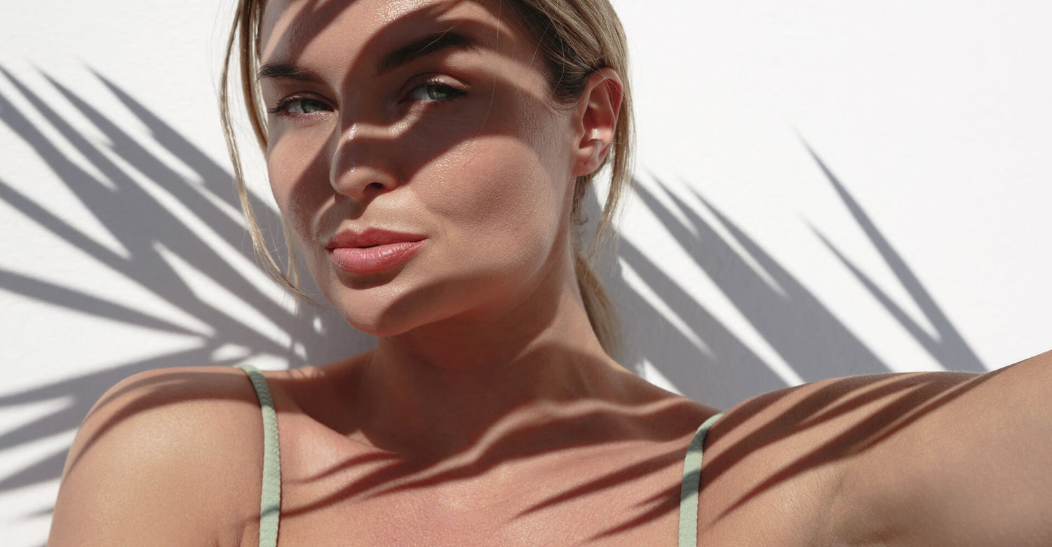 Woman with minimal makeup against a white background with palm leaf shadows - Ageless Medical Clinic