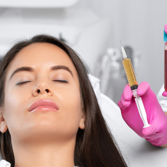 Woman receiving a blood test with a healthcare professional holding a syringe and blood sample tube.