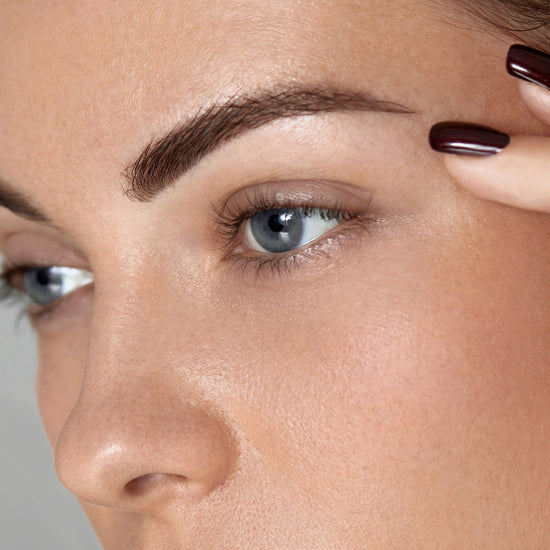 Close-up of a woman's face with a focus on her eye and eyebrow.