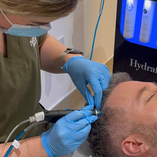 Person receiving a Hydrafacial treatment with medical equipment.