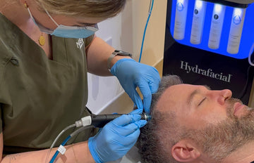 Person receiving a Hydrafacial treatment with medical equipment.