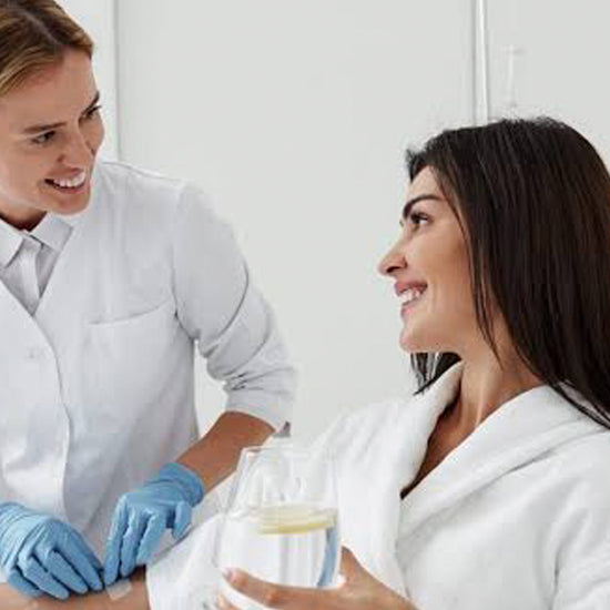 Woman receiving a skincare treatment from a professional in a clinical setting.