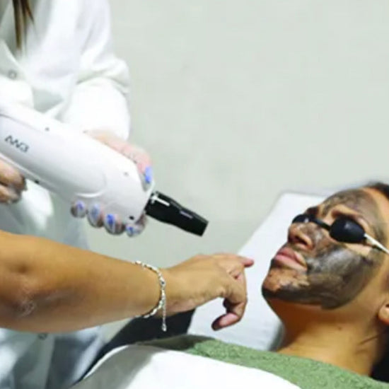 Person receiving a facial treatment with a device from a professional.